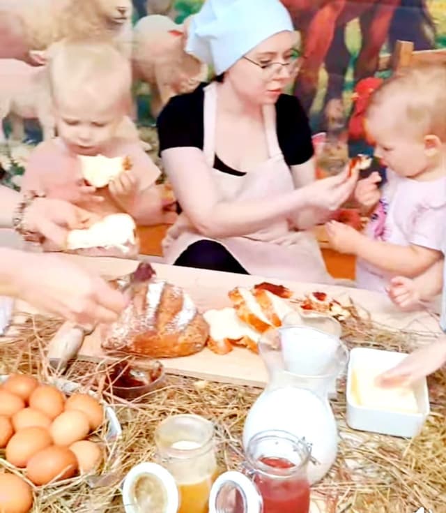 Maluchy jedzą świeży chleb przy wiejskim stole